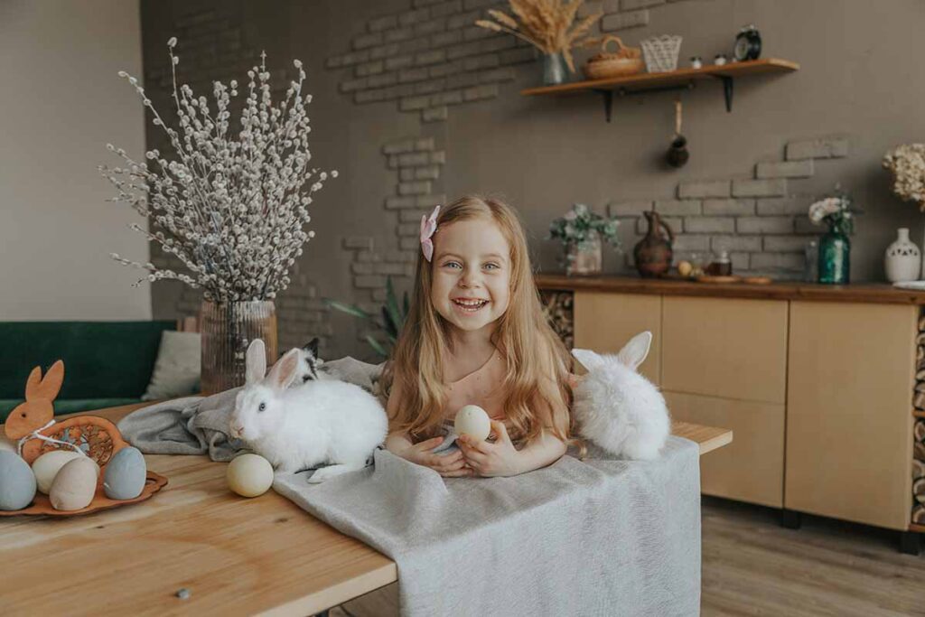 a rabbit sitting down on the table in side a kids sitting down in branch.